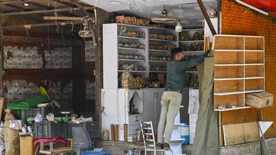 A trader comes back to his shop and unpacks after the market remained shut for 15 days. (RAJ K RAJ /HT PHOTO) A trader comes back to his shop and unpacks after the market remained shut for 15 days. (RAJ K RAJ /HT PHOTO)