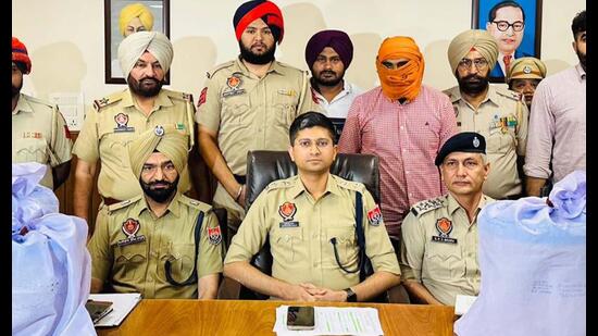 Accused in custody of the police. Tarn Taran SSP Abhimanyu Rana showing 85 kg heroin recovered from a smuggler on Friday. (HT Photo)
