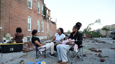 People sit outside next to bricks and debris after the destruction of the tornado in St. Louis, Missouri. (REUTERS)