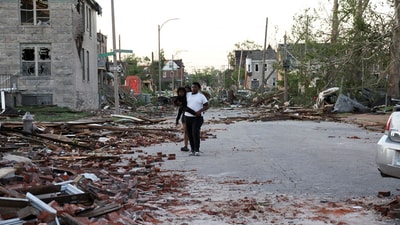 A person carries a child as they walk through a street covered in bricks and debris after a tornado hit their neighborhood in St. Louis, Missouri,U.S. May 16, 2025. REUTERS/Lawrence Bryant (REUTERS)