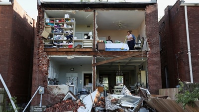 Residents inspect their home after a tornado completely tore off the back wall of a two-story house in St. Louis, Missouri. (REUTERS)