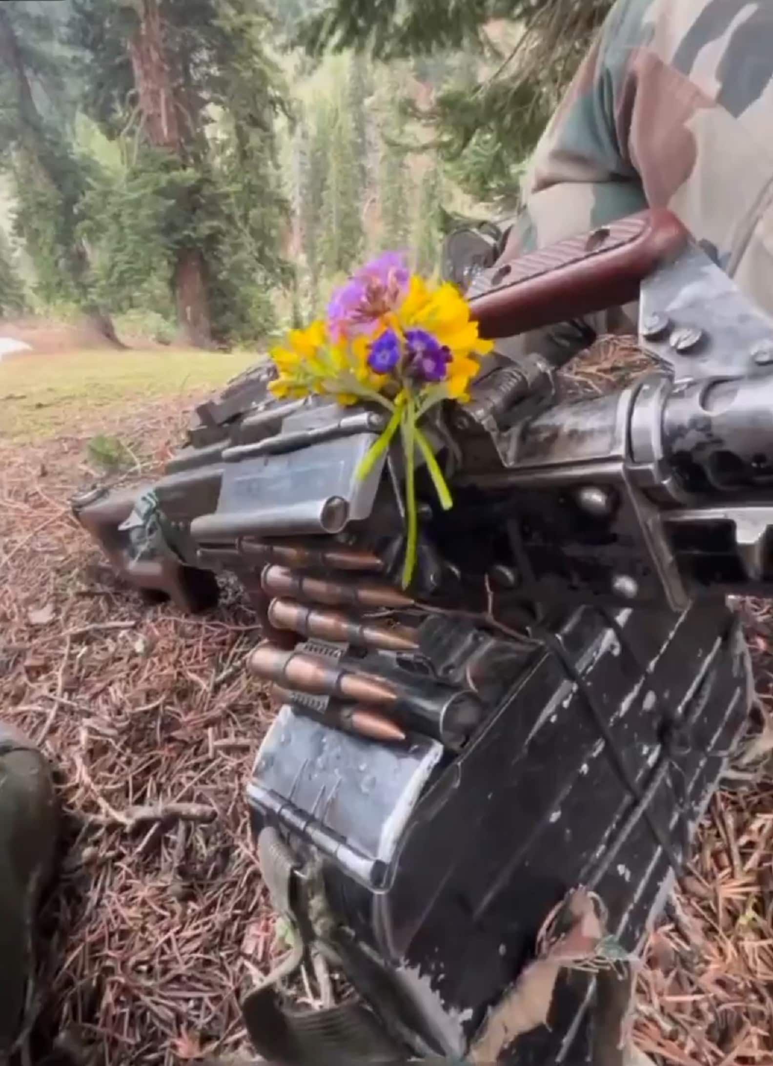 Guns & roses: Flowers adorn a machine gun of an Army patrol in Jammu Kashmir forests. Guns & roses: Flowers adorn a machine gun of an Army patrol in Jammu Kashmir forests.