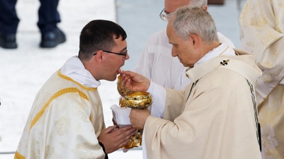 A solemn exchange as a clergy member receives the Eucharist from Pope Leo XIV at his inaugural Mass. REUTERS/REMO CASILLI (REUTERS)