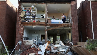 Residents inspect their home after a tornado completely tore off the back wall of a two-story house in St. Louis, Missouri.Keith Clark, whose family huddled in a closet during the storm, told USA Today “It was really bad. Then hearing neighbors scream and you can’t get to them, it’s pretty scary." (REUTERS)