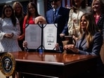 US President Donald Trump holds up the Take It Down Act after signing it with US First Lady Melania Trump at the White House on Monday. US President Donald Trump holds up the Take It Down Act after signing it with US First Lady Melania Trump at the White House on Monday.