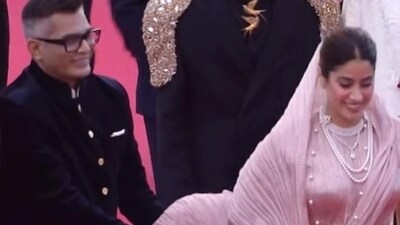 Neeraj Ghaywan holds up Janhvi Kapoor's outfit as she walks the Cannes Film Festival red carpet. Neeraj Ghaywan holds up Janhvi Kapoor's outfit as she walks the Cannes Film Festival red carpet.