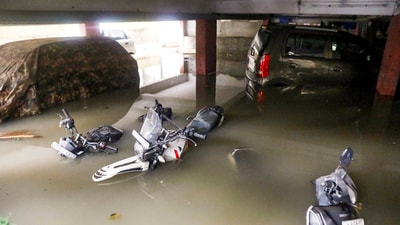 Vehicles partially submerged at the basement of an apartment following heavy rains, at Wilson Garden in Bengaluru, Monday, (PTI )