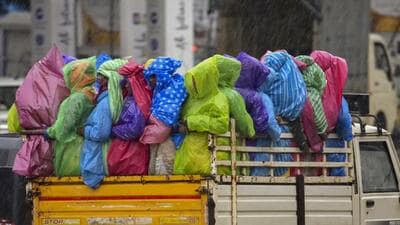 People travel in a tempo amid pre-monsoon showers in Chikkamagaluru, Karnataka, on Monday. (PTI Photo)