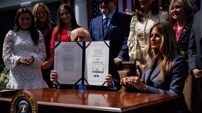 US President Donald Trump holds up the Take It Down Act after signing it with US First Lady Melania Trump at the White House on Monday. (Bloomberg) US President Donald Trump holds up the Take It Down Act after signing it with US First Lady Melania Trump at the White House on Monday. (Bloomberg)
