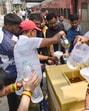 Volunteers distribute water to train passengers on a hot summer day in Jalandhar on Tuesday. (PTI)
