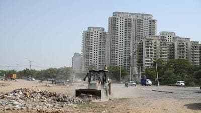 A GMDA team removing encroachments and construction debris from the Sector 82 road on Tuesday. (Parveen Kumar/HT Photo) A GMDA team removing encroachments and construction debris from the Sector 82 road on Tuesday. (Parveen Kumar/HT Photo)