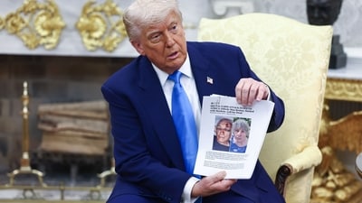 US President Donald Trump holds a news article during a meeting with Cyril Ramaphosa, South Africa's president, not pictured, in the Oval Office of the White House in Washington, DC, US, on Wednesday, May 21, 2025. Trump rejected Ramaphosa's argument that there is no genocide against White Afrikaners, airing a video and showing images in the Oval Office that he said showed how they were beaten and killed. Photographer: Jim Lo Scalzo/EPA/Bloomberg (Bloomberg) US President Donald Trump holds a news article during a meeting with Cyril Ramaphosa, South Africa's president, not pictured, in the Oval Office of the White House in Washington, DC, US, on Wednesday, May 21, 2025. Trump rejected Ramaphosa's argument that there is no genocide against White Afrikaners, airing a video and showing images in the Oval Office that he said showed how they were beaten and killed. Photographer: Jim Lo Scalzo/EPA/Bloomberg (Bloomberg)
