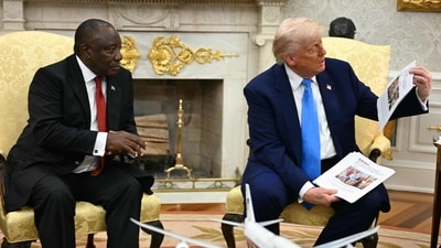 US President Donald Trump shows pictures and articles as he meets with South African President Cyril Ramaphosa in the Oval Office of the White House in Washington, DC, on May 21, 2025. South African President Cyril Ramaphosa meets Donald Trump on Wednesday amid tensions over Washington's resettlement of white Afrikaners that the US president claims are the victims of "genocide." (Photo by Jim WATSON / AFP) (AFP) US President Donald Trump shows pictures and articles as he meets with South African President Cyril Ramaphosa in the Oval Office of the White House in Washington, DC, on May 21, 2025. South African President Cyril Ramaphosa meets Donald Trump on Wednesday amid tensions over Washington's resettlement of white Afrikaners that the US president claims are the victims of "genocide." (Photo by Jim WATSON / AFP) (AFP)