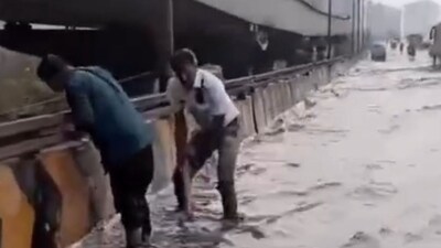 Bengaluru traffic cops manually declogging a flooded flyover to ease movement. (X/@Nimmabhaskar22) Bengaluru traffic cops manually declogging a flooded flyover to ease movement. (X/@Nimmabhaskar22)