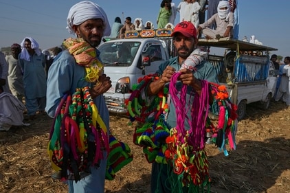 Hawkers hold colourful ribbons and other items using to decorate bull as they wait for customers at the venue of a traditional bull race competition, in Malal, a village of Attock district, in Pakistan. (Anjum Naveed/AP) Hawkers hold colourful ribbons and other items using to decorate bull as they wait for customers at the venue of a traditional bull race competition, in Malal, a village of Attock district, in Pakistan. (Anjum Naveed/AP)