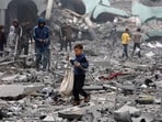 A young Palestinian boy salvages some items amid the devastation in the yard of a school, a day after it was hit by an Israeli strike.