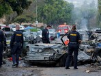 Emergency personnel work at the crash scene on a street, after a small civilian aircraft went down in a military neighborhood in San Diego