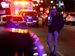A man speaks to an emergency personnel working at the site where, according to the U.S. Homeland Security Secretary, two Israeli embassy staff were shot dead near the Capital Jewish Museum in Washington, D.C., U.S. May 21, 2025.  REUTERS/Jonathan Ernst