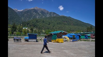 A man walks past closed roadside stalls in Pahalgam on Thurssday. (AP) A man walks past closed roadside stalls in Pahalgam on Thurssday. (AP)