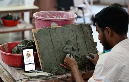 Sculptor busy shaping his piece of art, depicting a soldier at war (Deepak Gupta)