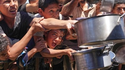 Palestinians struggle to receive cooked food distributed at a community kitchen in the Muwasi area of Khan Younis, in the Gaza Strip, Friday, May 23, 2025. (AP) Palestinians struggle to receive cooked food distributed at a community kitchen in the Muwasi area of Khan Younis, in the Gaza Strip, Friday, May 23, 2025. (AP)
