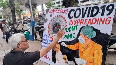 A teacher of the Gurukul School of Art makes an awareness painting of COVID-19, in Mumbai on Wednesday. (ANI)