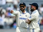 India's Virat Kohli talks with his captain Rohit Sharma (R) during India's Test series against New Zealand in 2024