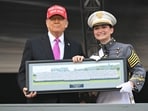 Trump receives a photo as a present after delivering the commencement address at the 2025 US Military Academy Graduation Ceremony at West Point.