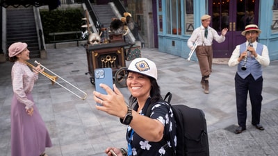 A woman uses her phone as performers play at "The Wizarding World of Harry Potter - Ministry of Magic" world in Universal Epic Universe theme park ahead of the grand opening celebration in Orlando, Florida, U.S. May 21, 2025. REUTERS/Marco Bello (REUTERS)