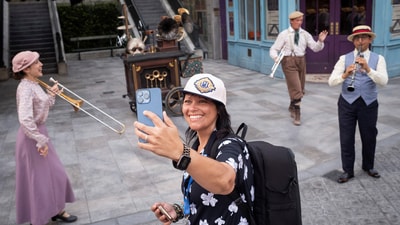 A woman uses her phone as performers play at "The Wizarding World of Harry Potter - Ministry of Magic" world in Universal Epic Universe theme park ahead of the grand opening celebration in Orlando, Florida, U.S. May 21, 2025. REUTERS/Marco Bello (REUTERS)