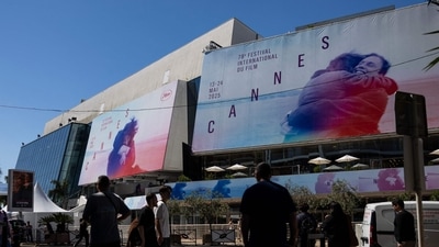 Pedestrians walk past posters of the 78th edition of the Cannes Film Festival outside the Palais des Festivals. (Photo by SAMEER AL-DOUMY / AFP) (AFP) Pedestrians walk past posters of the 78th edition of the Cannes Film Festival outside the Palais des Festivals. (Photo by SAMEER AL-DOUMY / AFP) (AFP)