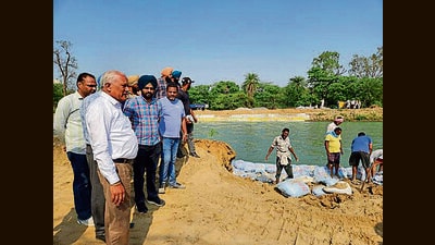 Officials inspecting the spot in Patiala where the breach in the Bhakra Canal was being plugged on Saturday. (HT Photo)