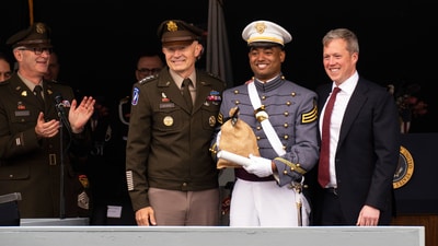 Army Chief of Staff Gen. Randy A. George, left, and Army Secretary Daniel P. Driscoll, right, stand with the "goat" cadet, or lowest-ranking class member, Temon Michael-Malik Birchett, who is holding the traditional bag of money in collections from peers, during the United States Military Academy commencement ceremonies in West Point, N.Y., Saturday, May 24, 2025. (AP Photo/Adam Gray) (AP) Army Chief of Staff Gen. Randy A. George, left, and Army Secretary Daniel P. Driscoll, right, stand with the "goat" cadet, or lowest-ranking class member, Temon Michael-Malik Birchett, who is holding the traditional bag of money in collections from peers, during the United States Military Academy commencement ceremonies in West Point, N.Y., Saturday, May 24, 2025. (AP Photo/Adam Gray) (AP)