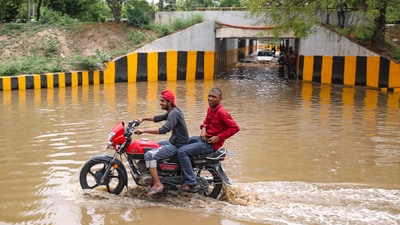 Men ride a motorcycle through a waterlogged area at Sector 146 on the Noida-Greater Noida Expressway following Wednesday's heavy rainfall. (PTI) Men ride a motorcycle through a waterlogged area at Sector 146 on the Noida-Greater Noida Expressway following Wednesday's heavy rainfall. (PTI)