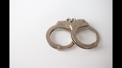 A high angle shot of metal handcuffs isolated on a white background A high angle shot of metal handcuffs isolated on a white background