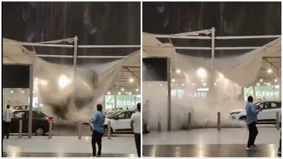 As the rain intensifies, the membrane shade partially collapses, giving way and allowing water to pour down onto the vehicles and flow toward those nearby, prompting them to move away. (X/@WeatherMonitors) As the rain intensifies, the membrane shade partially collapses, giving way and allowing water to pour down onto the vehicles and flow toward those nearby, prompting them to move away. (X/@WeatherMonitors)