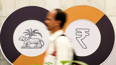 A man walks past a logo of the Reserve Bank of India (RBI) and the Indian Rupee inside the RBI headquarters in Mumbai. (REUTERS)