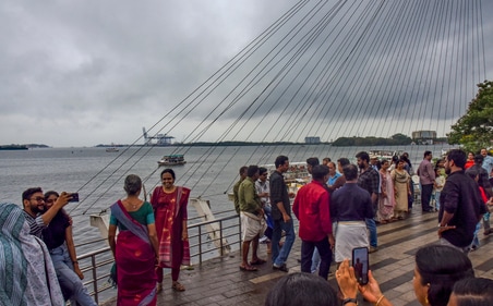 Visitors at Marine Drive as dark clouds cover the skyline, in Kochi, Kerala, Saturday after the southwest monsoon hit Kerala (PTI) Visitors at Marine Drive as dark clouds cover the skyline, in Kochi, Kerala, Saturday after the southwest monsoon hit Kerala (PTI)