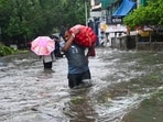 A man seen carrying a sack on a water-logged road in Mumbai. A man seen carrying a sack on a water-logged road in Mumbai.