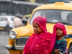 A woman holding her child walks along a road amid rain, in Kolkata, Monday. A woman holding her child walks along a road amid rain, in Kolkata, Monday.