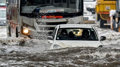 A car lies partially submerged as it wades through a flooded street after heavy rain showers in Mumbai on May 26, 2025. (AFP) A car lies partially submerged as it wades through a flooded street after heavy rain showers in Mumbai on May 26, 2025. (AFP)