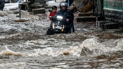 A man pushes his bike through a flooded street after heavy rain showers in Mumbai. (Punit Paranjpe/AFP) A man pushes his bike through a flooded street after heavy rain showers in Mumbai. (Punit Paranjpe/AFP)