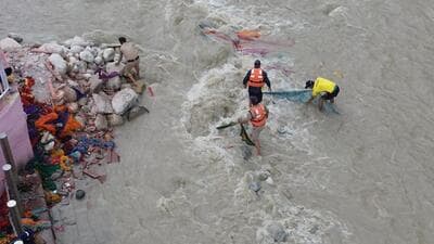 Panchayat workers collecting clothes from the Ganga in Gangotri area of Uttarkashi district. (HT Photo) Panchayat workers collecting clothes from the Ganga in Gangotri area of Uttarkashi district. (HT Photo)