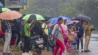 People wait for transport vehicles amid rain, in Bengaluru, on Monday (PTI) People wait for transport vehicles amid rain, in Bengaluru, on Monday (PTI)