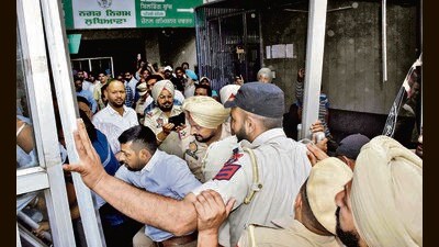 The protesters attempted to lock the office and broke the main glass door, pushing their way inside the MC Zone D office in Ludhiana on Monday. (Manish/HT)