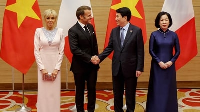 Vietnam's President Luong Cuong (2R) shakes hands with his French counterpart Emmanuel Macron (2L) as their respective wives Nguyen Thi Minh Nguyet (R) and Brigitte Macron pose during a state dinner at the International Convention Center in Hanoi on May 26, 2025. (Photo by Ludovic MARIN / AFP) (AFP) Vietnam's President Luong Cuong (2R) shakes hands with his French counterpart Emmanuel Macron (2L) as their respective wives Nguyen Thi Minh Nguyet (R) and Brigitte Macron pose during a state dinner at the International Convention Center in Hanoi on May 26, 2025. (Photo by Ludovic MARIN / AFP) (AFP)