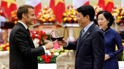 Vietnam's President Luong Cuong (C) clinks a glass with his French counterpart Emmanuel Macron (L) as his wife Nguyen Thi Minh Nguyet watches during a state dinner at the International Convention Center in Hanoi on May 26, 2025. (Photo by Ludovic MARIN / AFP) (AFP) Vietnam's President Luong Cuong (C) clinks a glass with his French counterpart Emmanuel Macron (L) as his wife Nguyen Thi Minh Nguyet watches during a state dinner at the International Convention Center in Hanoi on May 26, 2025. (Photo by Ludovic MARIN / AFP) (AFP)