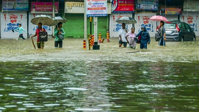 Pedestrians wade through an inundated road amid rains, in Mumbai, Monday, May 26, 2025. (PTI) Pedestrians wade through an inundated road amid rains, in Mumbai, Monday, May 26, 2025. (PTI)