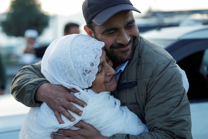 A Kashmiri hajj pilgrim in Srinagar, Kashmir, India, smiles as she hugs her son before departing for Mecca for the annual pilgrimage to the holiest place for Muslims. (Image by REUTERS/Sharafat Ali)