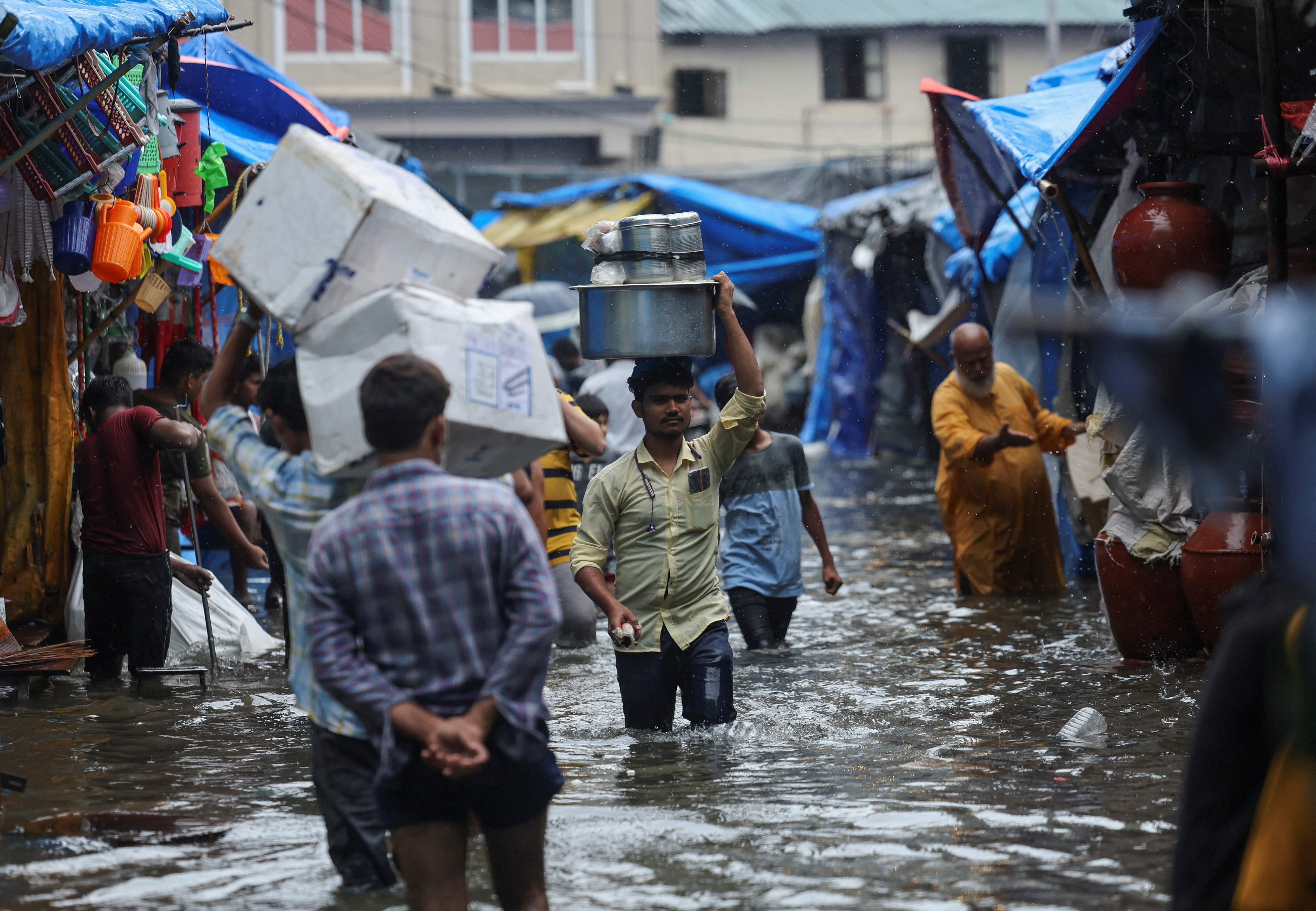 A man wades through a waterlogged street following heavy rainfall in Mumbai on May 26, 2025. (REUTERS)
